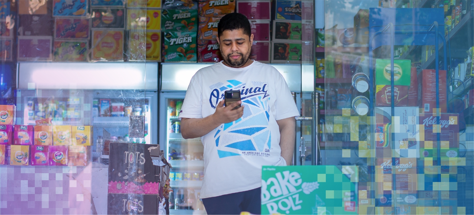 shopkeeper standing in front of store holding phone